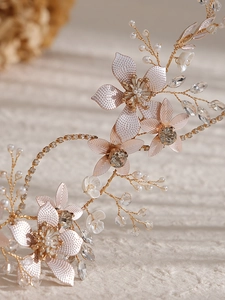 Vue détaillée d'un bandeau de mariée avec fleurs en métal rose et perles de cristal