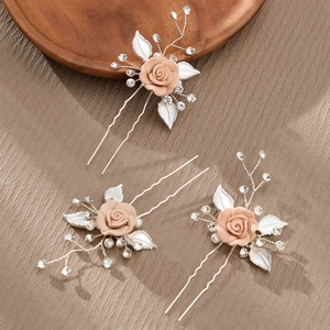 Close-up of three-piece handmade pearl rose hair pins with silver leaves and crystals