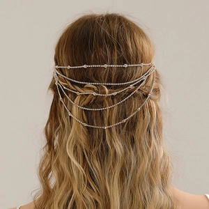 Detailed back view of layered golden rhinestone hair chain on blonde wavy hair