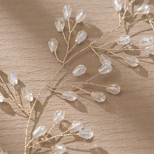 Vue rapprochée du serre-tête de mariée fait main en fil doré et perles de cristal