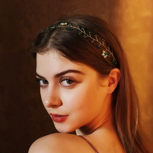Dettaglio della fascia da sposa con perline verde smeraldo e texture in filo dorato
