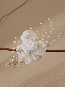 Detailed close-up of handmade bridal flower hair clip with white pearls and crystals