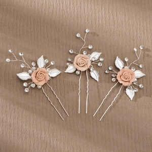 Detailed macro view of handmade pink fabric flowers and faux pearls on bridal hair pins