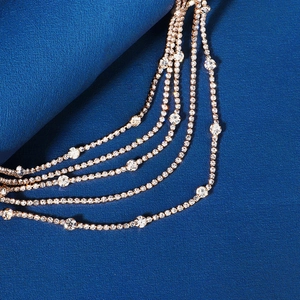 Detailed close-up of multilayer rhinestone fringe headpiece with gold-tone metal settings