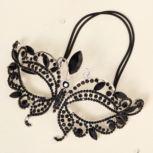 Macro detail of butterfly masquerade mask with black rhinestones and silver metal frame