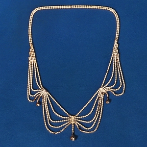 Detail of bridal gold tiered chain headpiece with rhinestone tassels and bead pendants