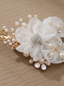 Macro detail of handmade organza flower hair clip with pearls and crystal stamen