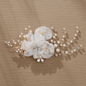 Elegant bridal hair clip with white mesh flowers, pearls, and gold leaves for weddings