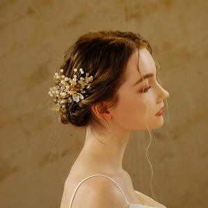 Golden bridal hair comb with pearls and crystals shown on model side profile