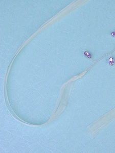 Close-up of handmade purple crystal beads wired on a bridal hairband with ribbon