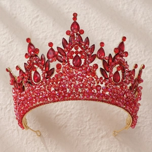Close-up of golden crown with red teardrop crystals and sparkling rhinestones