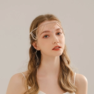 Detail of bohemian gold forehead chain with crystal tassels for bridal wedding hair