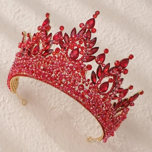 Close-up of luxury bridal crown with red crystals and gold-plated metal frame