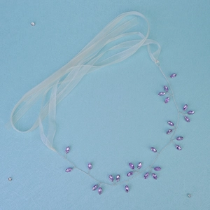 Handmade bridal headband with purple crystals and silver wire on a light blue background
