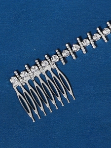 Detail view of bridal hair comb with shimmering rhinestones and soft chain link decoration