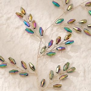 Detailaufnahme von Brautkopfschmuck mit schillernden Kristallperlen und Golddraht