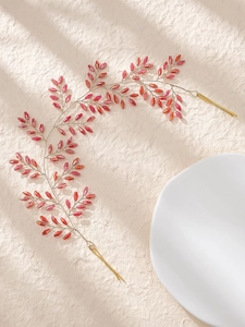 Detail eines handgefertigten Brauthaarschmucks mit rosa Perlen und goldenem Metalldraht