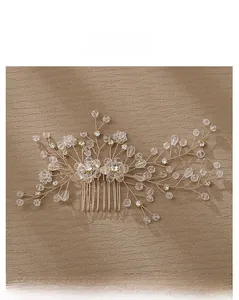 Detailed close-up of handmade bridal hair comb with crystal beads and gold wire flowers