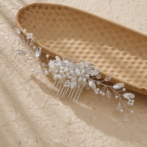 Elegant bridal hair comb with pearls and crystals on a decorative vintage tray
