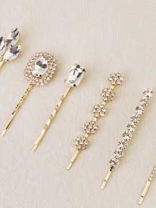 Detailed view of elegant gold hair pins with various sparkling clear crystal rhinestones