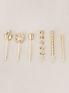 Detail of 6-piece gold-toned hair clip set featuring rhinestones and geometric shapes