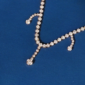 Detailed close-up of crystal bridal forehead chain with gold plating and rhinestones