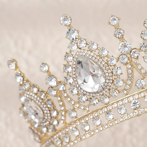 Gros plan macro sur une luxueuse couronne de mariée dorée avec strass et joyau en goutte
