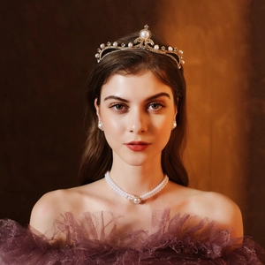 Dettaglio del set di diadema dorato, collana di perle a doppio filo e orecchini di lusso