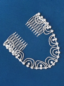 Detailed close-up of a silver bridal hair comb with shimmering rhinestone chains
