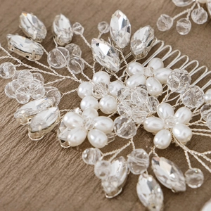 Detailweergave van de handgemaakte bruidshaarkam met witte parels en heldere kristallen