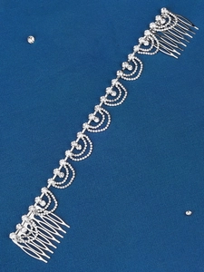 Macro detail of bridal silver rhinestone hair comb with sparkling chain links and alloy base