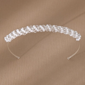 Dettaglio del cerchietto da sposa intrecciato con cristalli scintillanti e perle