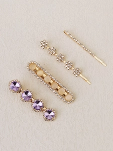 Detail of four-piece gold alloy hair clip set with purple rhinestones and beige opals