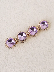 Detail of gold bobby pin featuring four purple crystals with micro-pave rhinestone halos