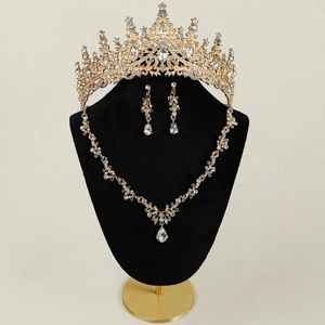 Détail d'une parure de bijoux de mariée dorée avec diadème, collier et boucles d'oreilles