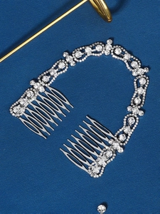 Detailed close-up of bridal hair comb with sparkling rhinestones and silver metal teeth