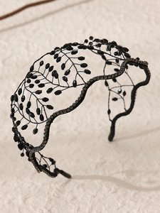 Detail of handmade black beaded mesh headband with intricate gothic leaf crystals
