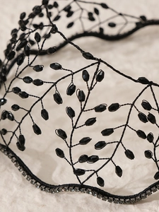 Close-up of handmade black woven branch headband with faceted beads and silver rhinestones