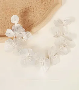 Close-up of bridal headband with handmade white hollow lace petals and pearl accents