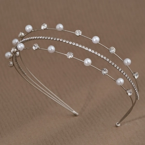 Détail d'un serre-tête argenté à trois rangs avec perles blanches et strass brillants