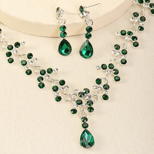 Vue rapprochée de la parure de mariée avec cristaux vert émeraude et boucles d'oreilles
