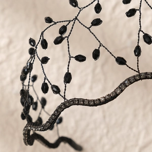 Detail view of handmade woven mesh headband featuring black beads and rhinestones