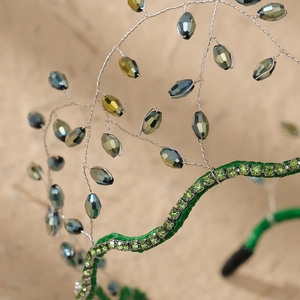 Macro shot of forest green headband with crystals and silver wire branch details