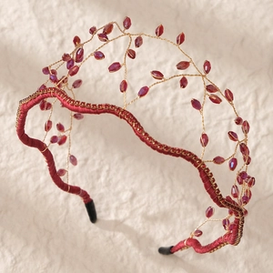 Macro detail of handmade mesh headband with burgundy crystal beads and gold wire vines