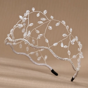 Close-up of handmade silver crown headband with crystal beads and intricate branch design