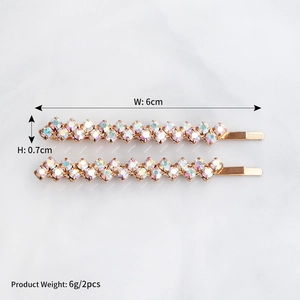 Detail shot of two gold rhinestone hair clips on marble background with 6cm size specs