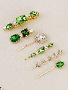 Detailed macro view of 6-piece emerald and crystal hair clip set on golden alloy base