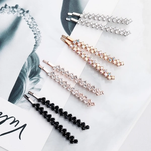 Detailed macro view of four sets of double-row rhinestone hair clips on marble