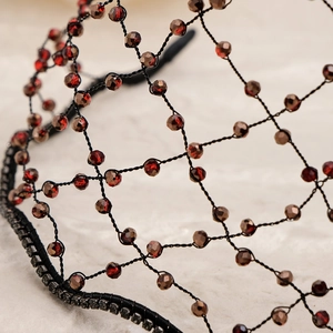 Macro detail of handmade mesh headband with ruby crystals and sparkling rhinestones