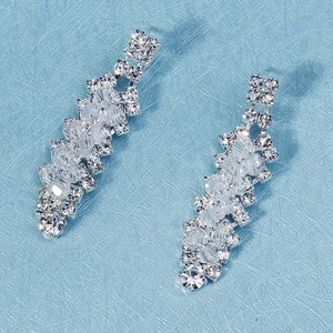 Dettaglio di orecchini da sposa in argento con frange di cristallo e motivi floreali chic
